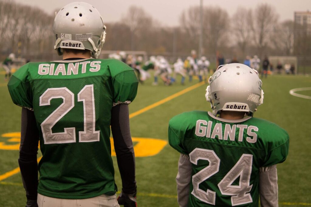 Senior And Junior Football Player in the Field