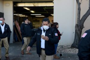 Men wearing face masks gather for a Mike Counsil Plumbing event in San Jose, CA