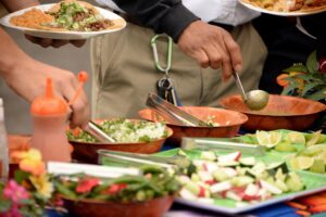 At the Mike Counsil Plumbing and Rooter event in San Jose, CA, a man serves food to attendees.