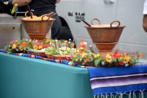 A table at the Mike Counsil Plumbing and Rooter event in San Jose, CA, featuring two pots of food