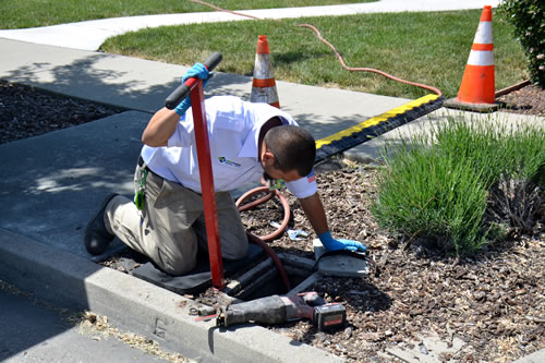 The man is working in a manhole.