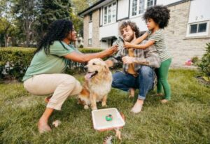 A happy family of three playing with their golden retriever