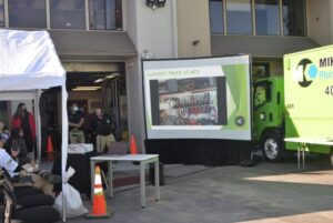 A green truck featuring a rooftop screen, situated in San Jose, CA, illustrating innovative design.