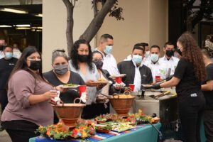 Guests stand by a table of food at the Mike Counsil Plumbing and Rooter event in San Jose, CA.