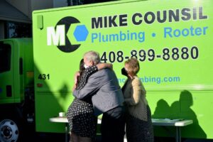 Mike Counsil Plumbing and Rooter president, hugs an attendee at an event in San Jose, CA.